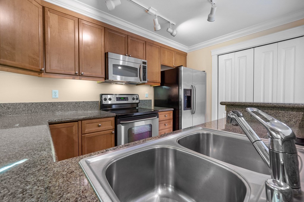 a kitchen with granite countertops and stainless steel appliances