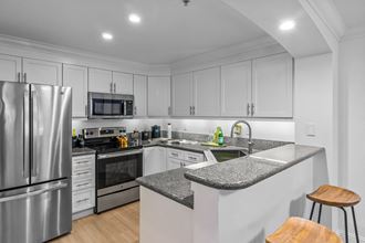 a kitchen with white cabinets and a gray counter top - Photo Gallery