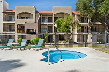 A pool in front of a building with a fence around it.