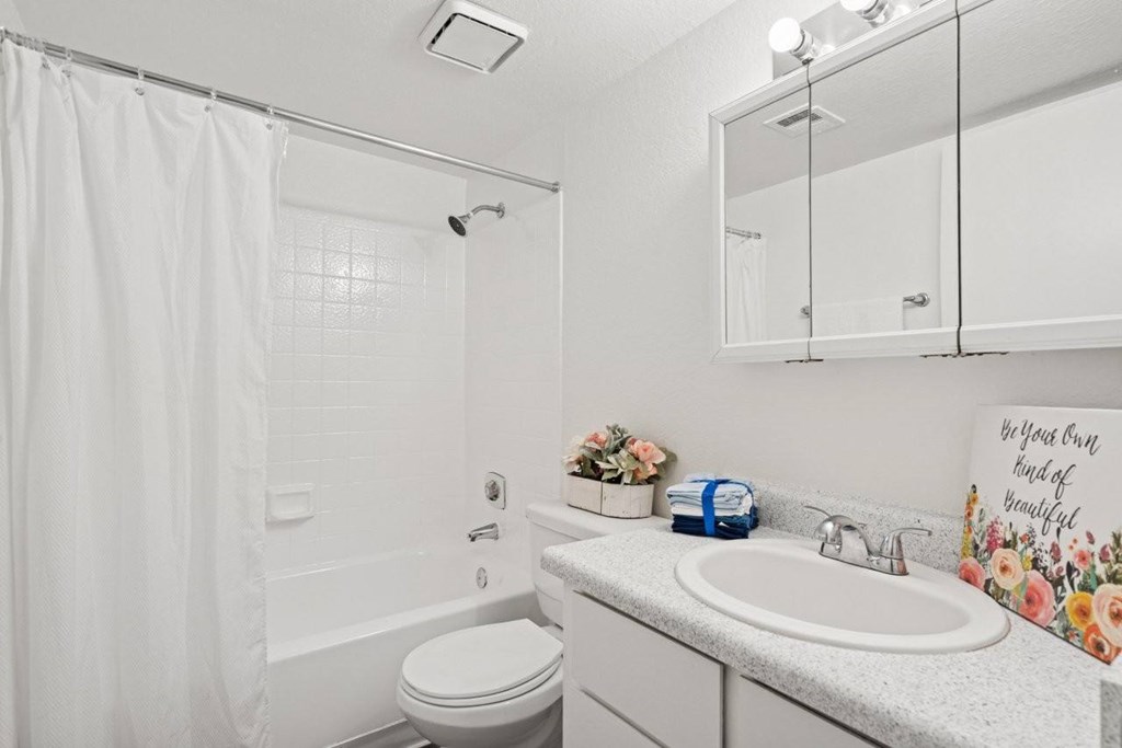 Casa Bella  A white bathroom with a toilet, sink, and shower.
