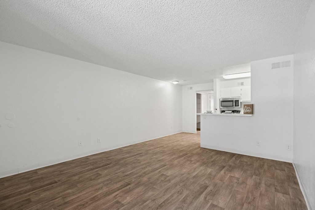 A room with wooden flooring and white walls.