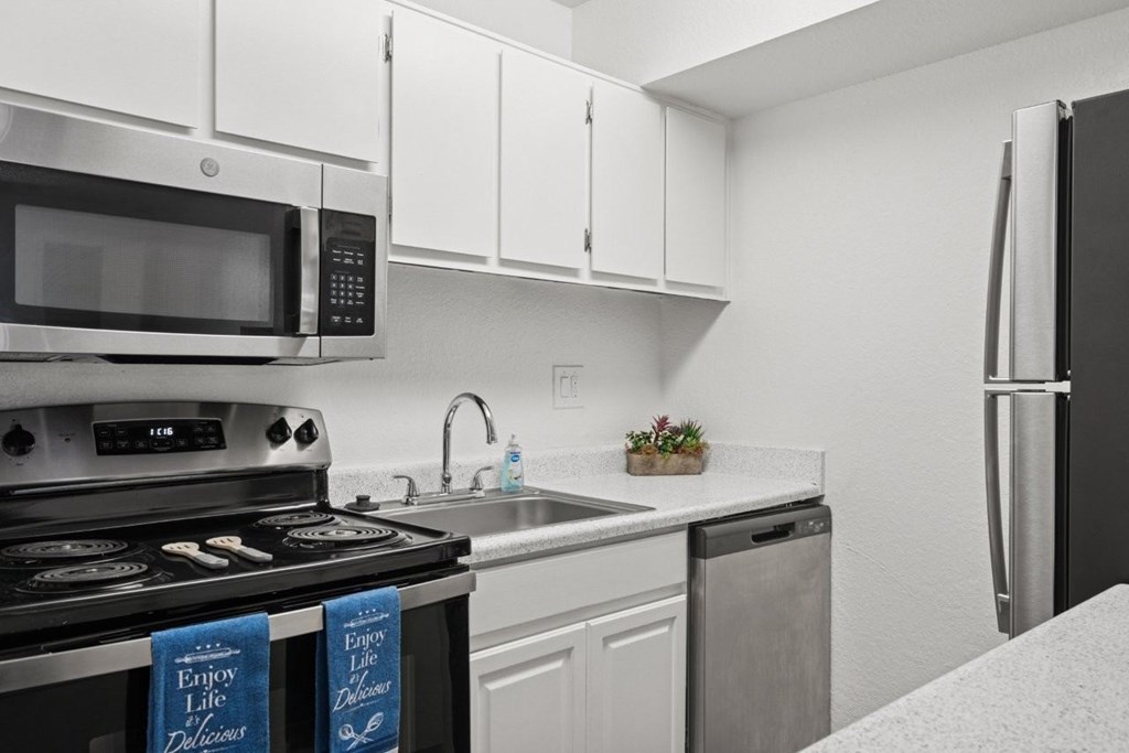 Casa Bella  A kitchen with a stove, microwave, and refrigerator.