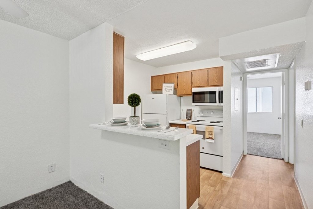 A kitchen with white walls and wooden accents.