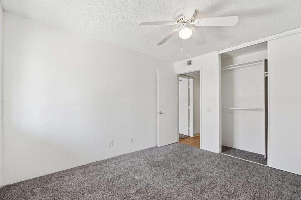 Casa Bella bedroom with white walls, carpet and ceiling fan