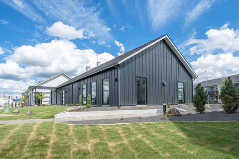 A modern house with a grey exterior and a sloped roof.