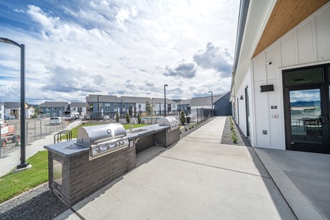 A long concrete walkway leads to a building with a glass door.