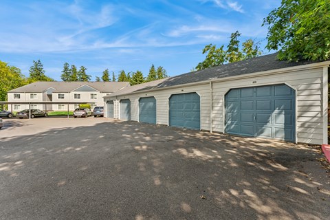 A parking lot with a building and a tree in the background.
