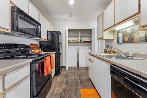 A kitchen with black appliances and white cabinets.