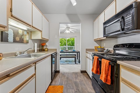 A kitchen with white cabinets and a black stove top oven.