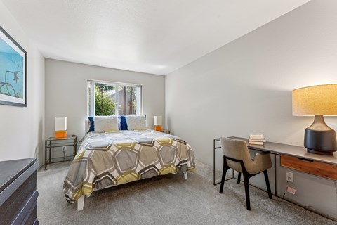 A bedroom with a bed, desk, and chair.