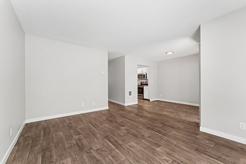A room with wooden flooring and white walls.