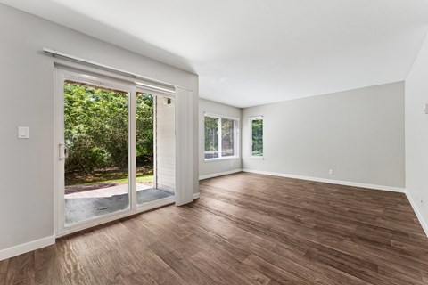 A room with a sliding glass door leading to a backyard.