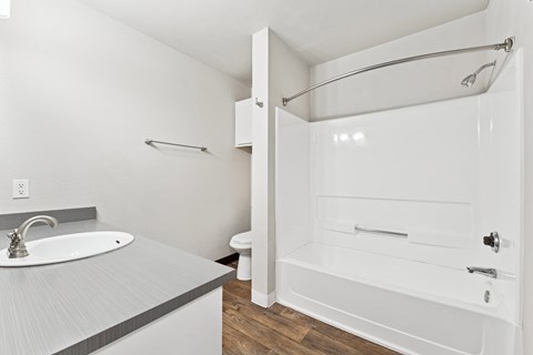 A white bathroom with a sink, toilet, and bathtub.