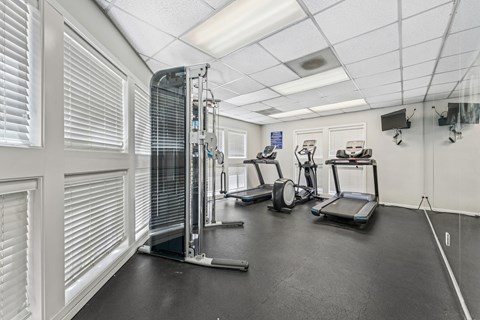 A gym with treadmills, elliptical machines, and other exercise equipment.