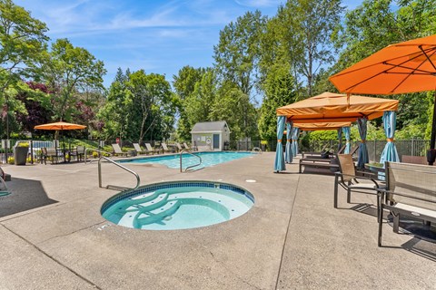 A pool with a hot tub and a sunshade.