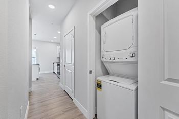 A white washing machine is in a white door.