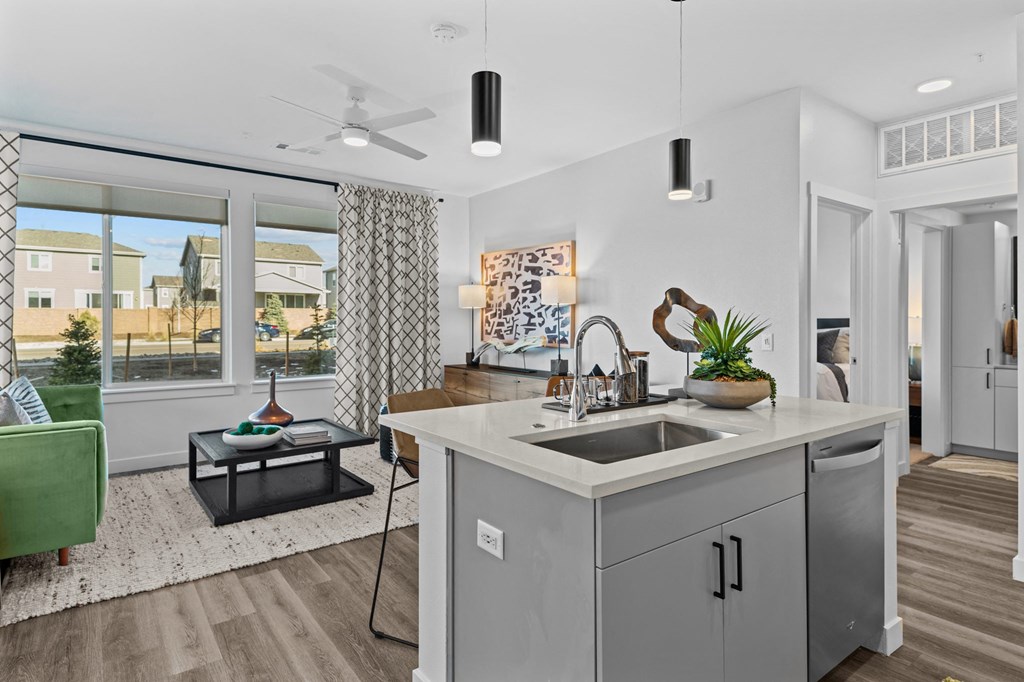 an open living room and kitchen with a large window and a sink