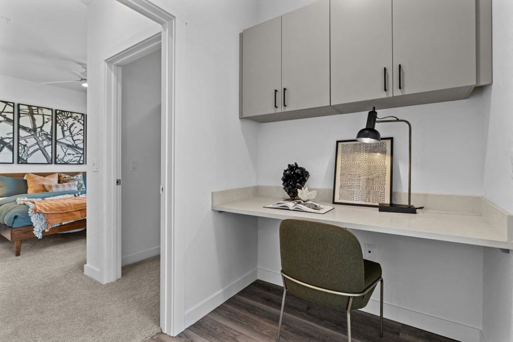 a small desk in a room with a door to a bedroom