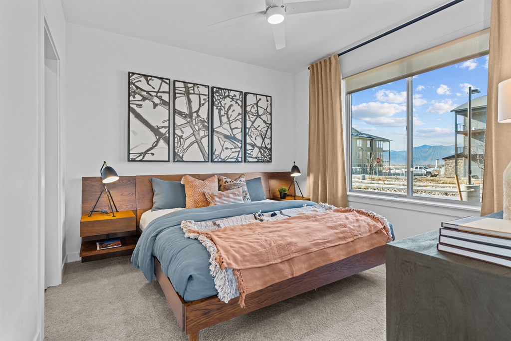 Aura Crossroads Apartments bedroom with large bed and ceiling fan