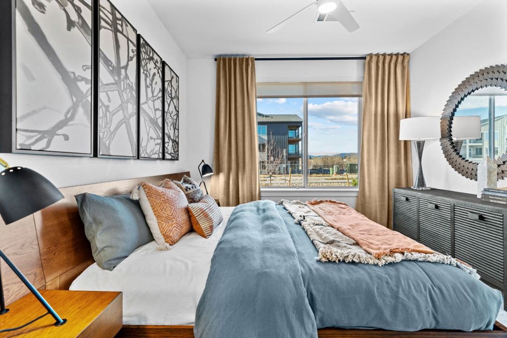 a bedroom with a bed and a large window