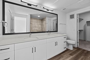 a bathroom with white cabinets and a large mirror