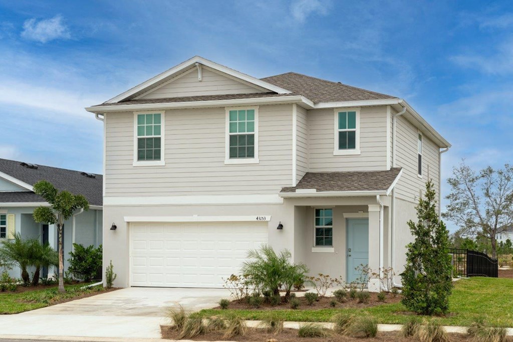 a white house with green shutters and a driveway