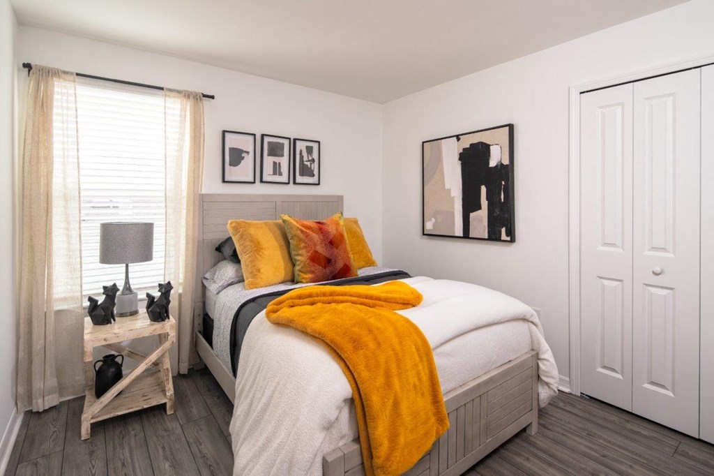 a room with striped wallpaper and a bed with a yellow blanket