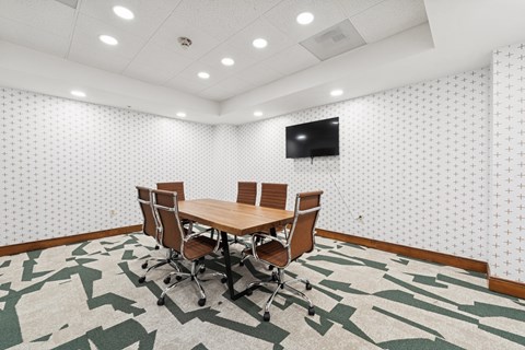 A conference room with a large table and chairs.
