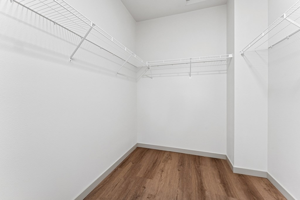 Empty room with white walls and wooden floor.
