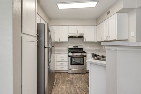 a kitchen with white cabinets and stainless steel appliances