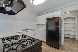 a kitchen with white cabinets and a black refrigerator and stove
