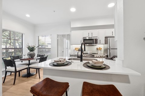A modern kitchen with a dining table and chairs.