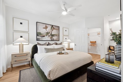 A bedroom with a large bed and a ceiling fan.