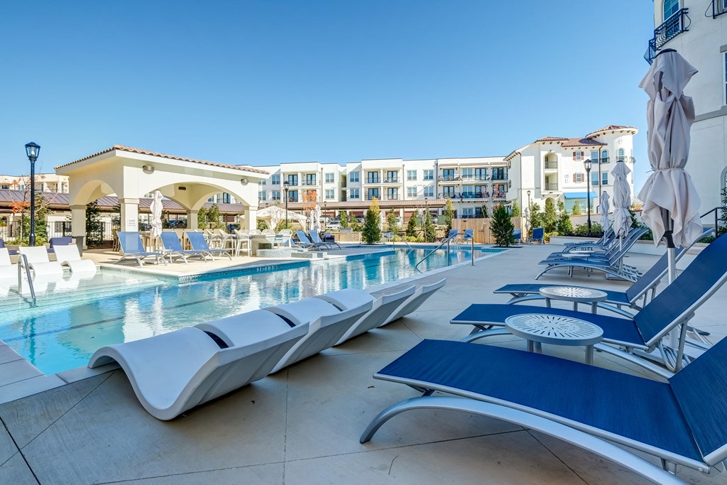 The Dylan  resort style pool with lounge chairs and umbrellas