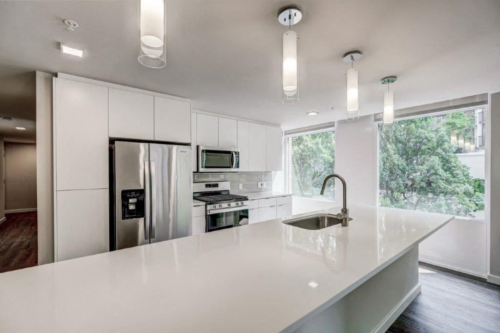 a white kitchen with a sink and a refrigerator