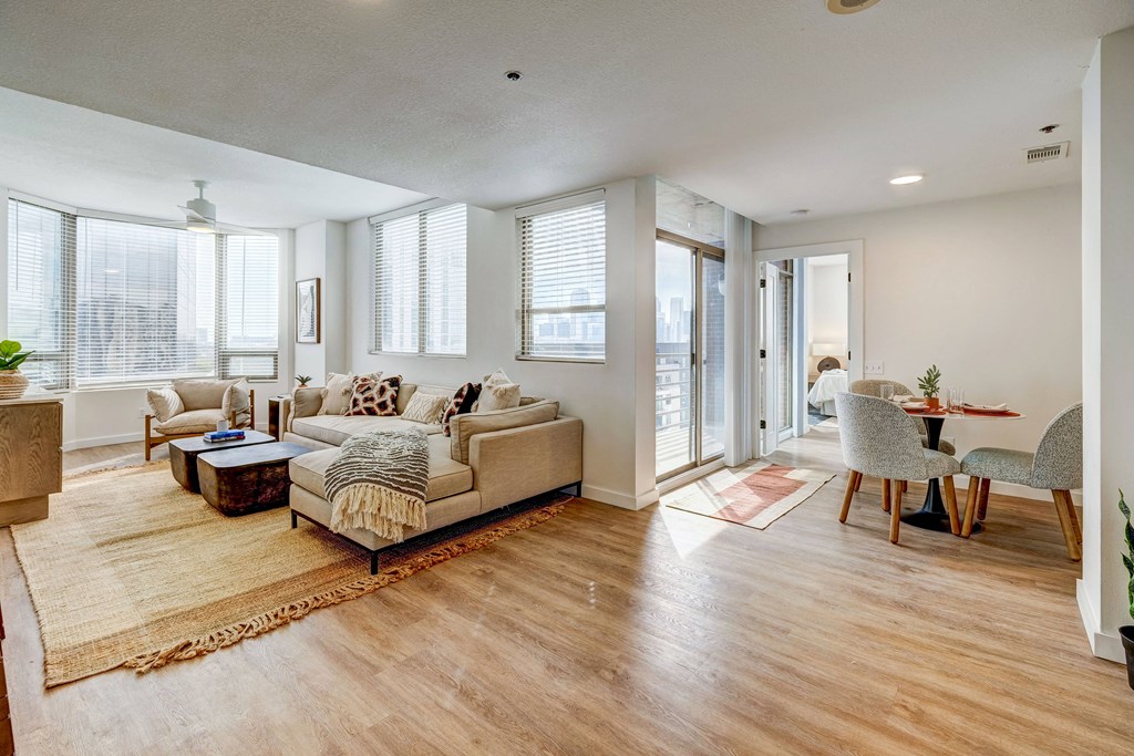a living room with a couch and chairs and a dining room table