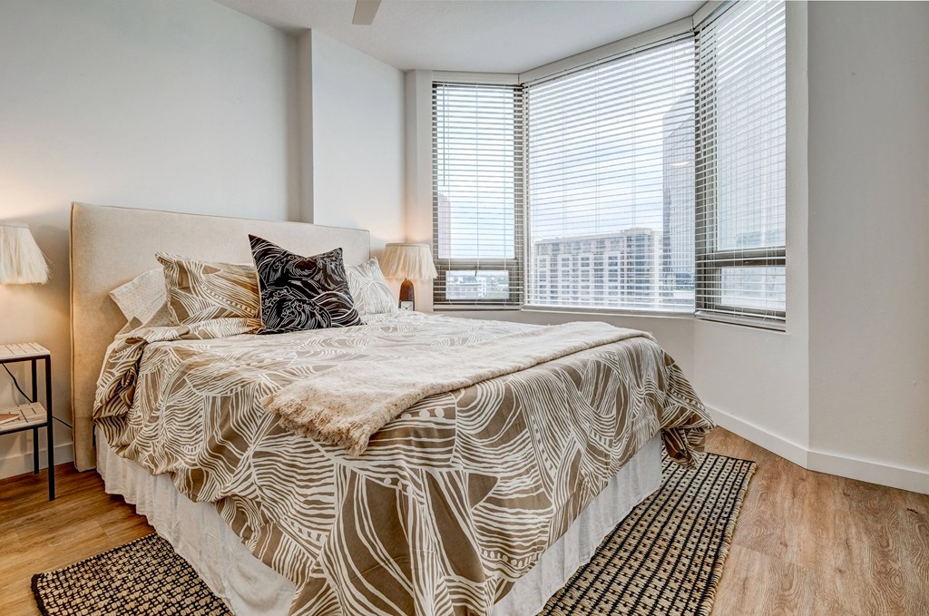 a bedroom with a large bed and two windows