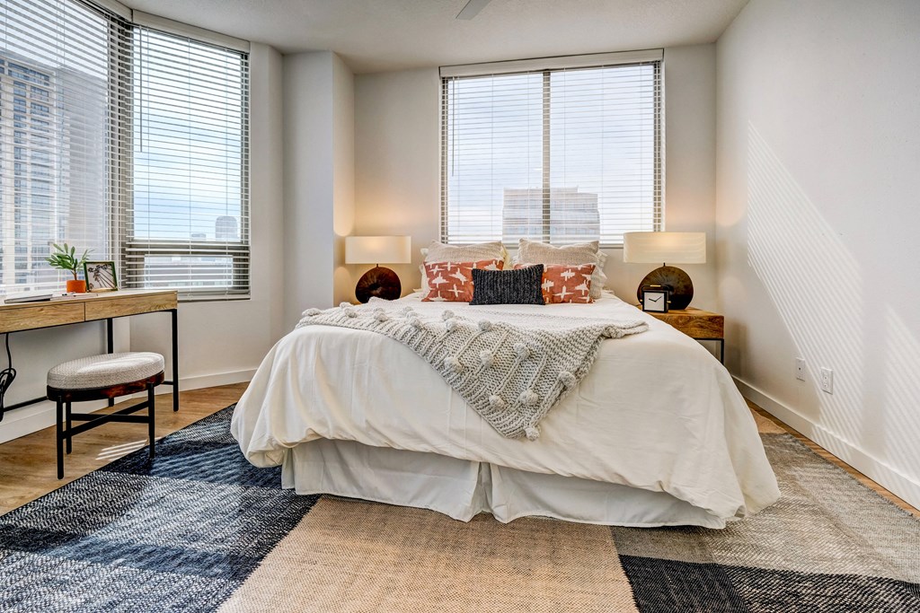 a bedroom with a bed and three windows