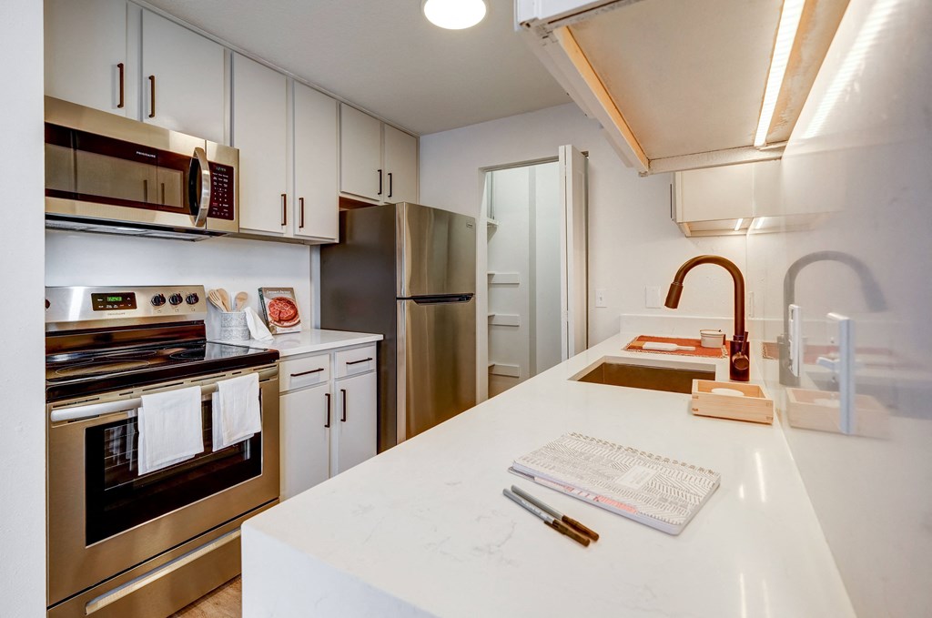 a kitchen with stainless steel appliances and a white counter top