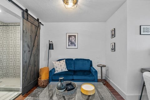 a living room with a blue couch and a sliding barn door