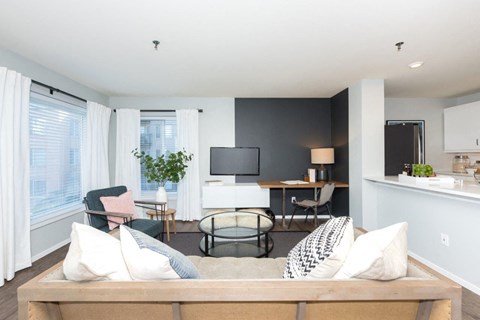 a living room with a couch and chairs and a tv