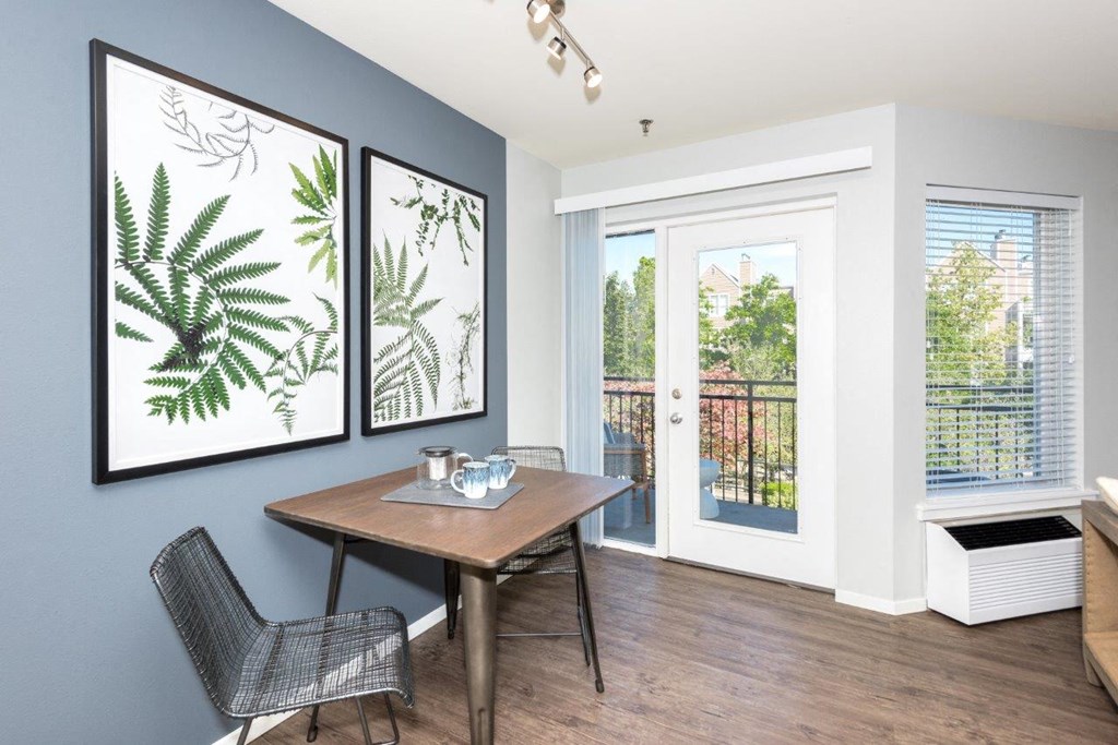 a dining room with a table and chairs and a door to a balcony