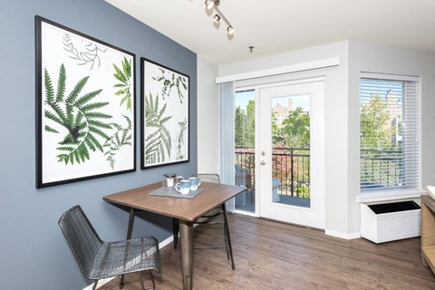 a dining room with a table and chairs and a door to a balcony
