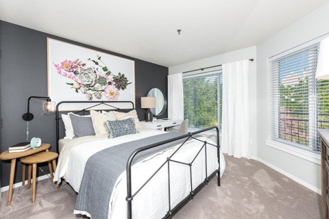 a bedroom with a bed and two windows