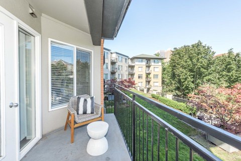 a balcony with a chair and a table on a balcony