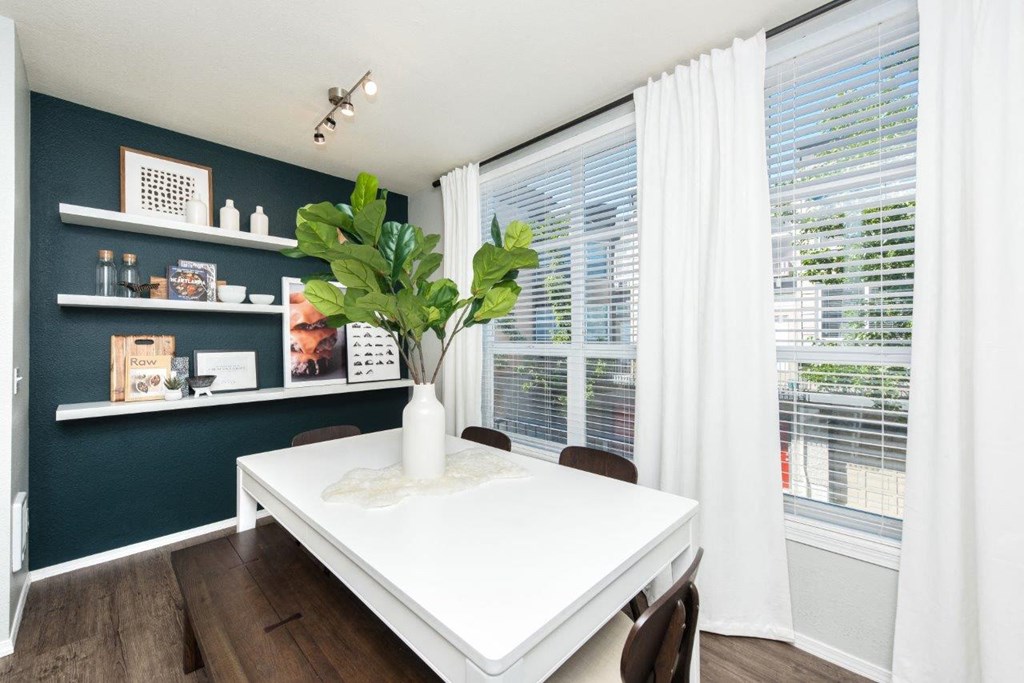 a dining room with a white table and a large window