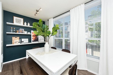 a dining room with a white table and a large window