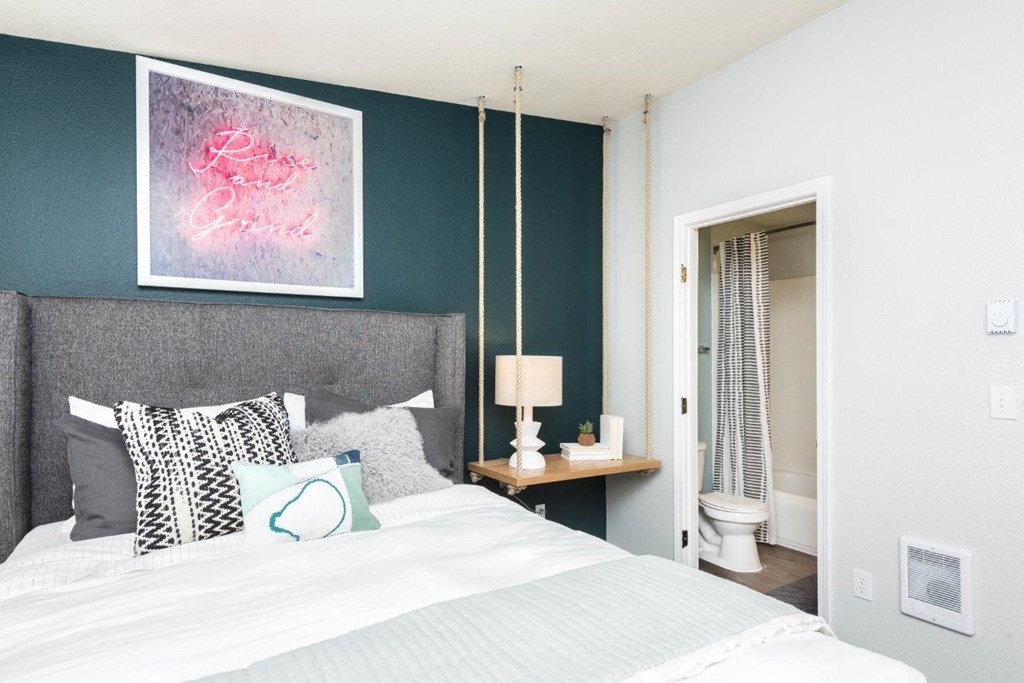 a bedroom with a bed and a painting on the wall