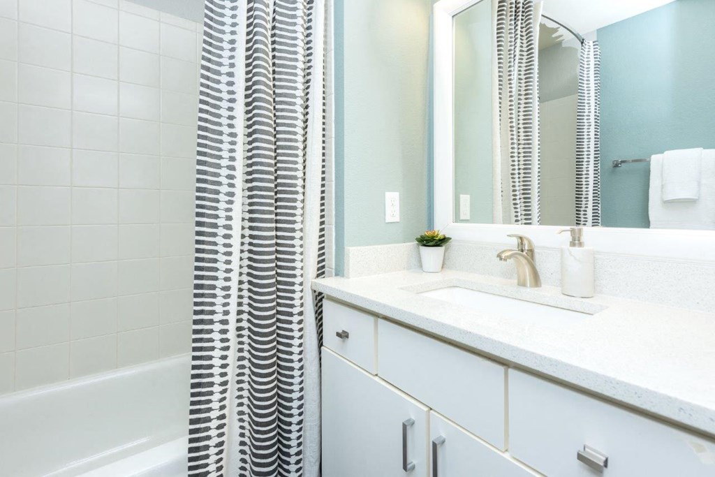 a white bathroom with a sink and a mirror