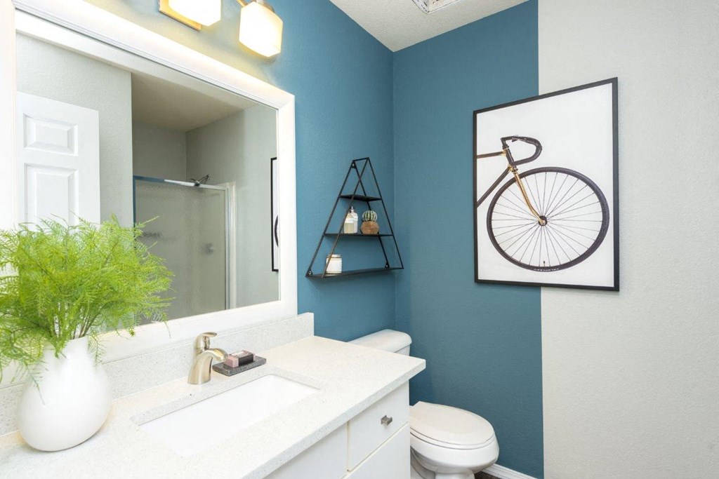 a bathroom with a mirror and a bike on the wall